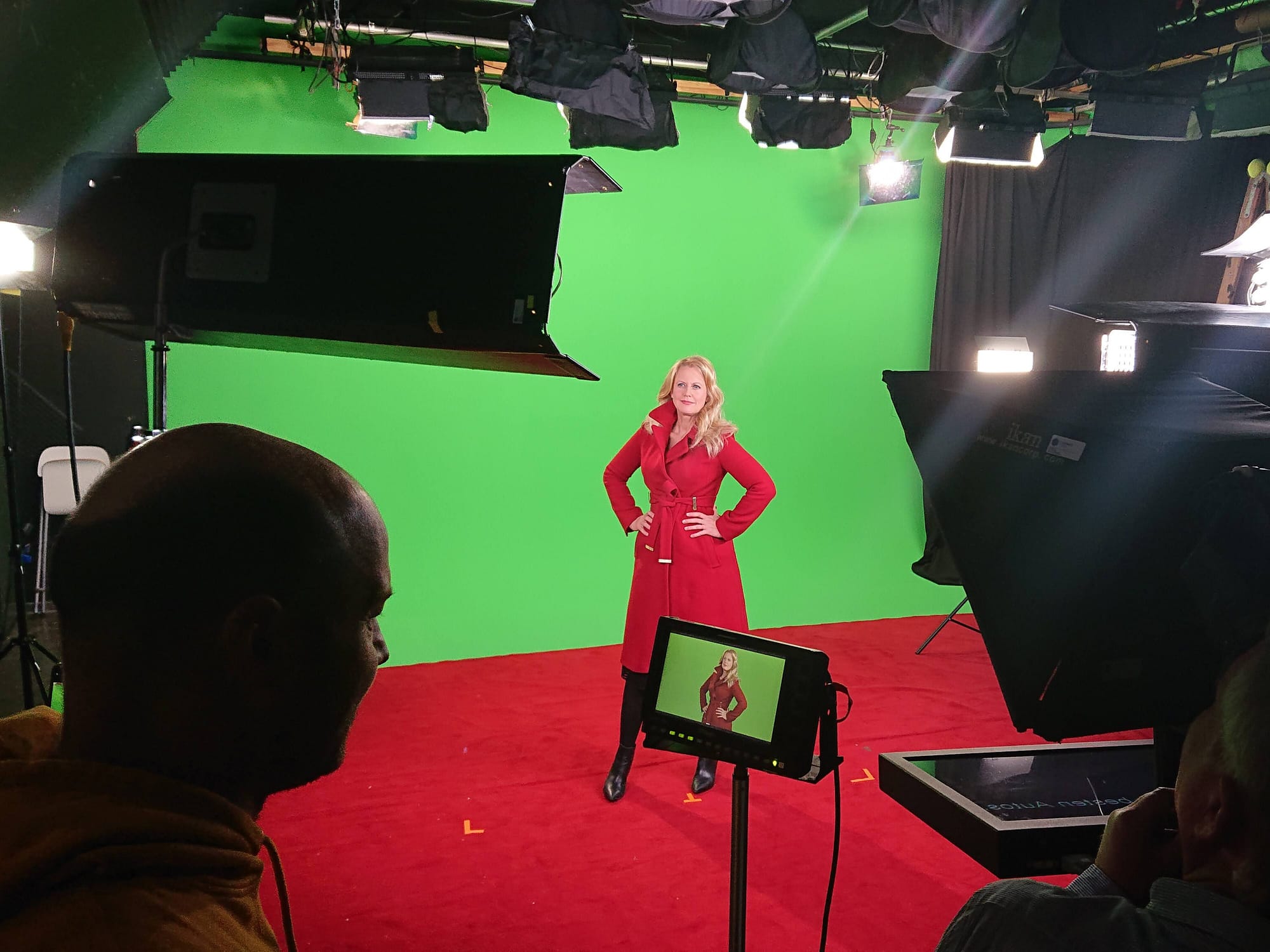 Star posing in front of a greenscreen while being recorded